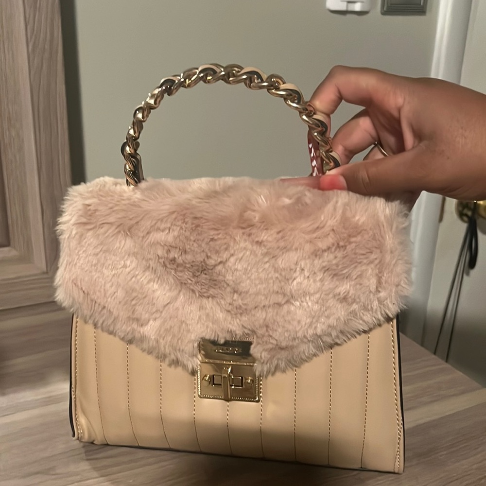 Tan faux fur aldo purse with gold detailing.